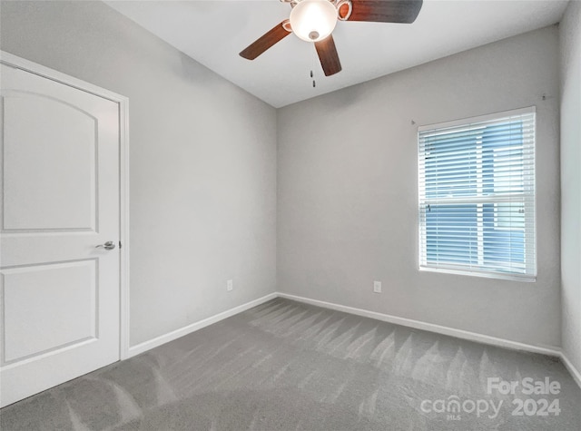 spare room featuring ceiling fan, carpet, and baseboards