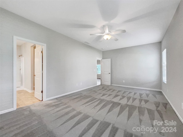 carpeted empty room featuring ceiling fan and baseboards