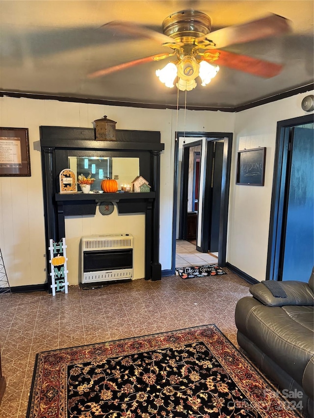 living room with crown molding, ceiling fan, and heating unit