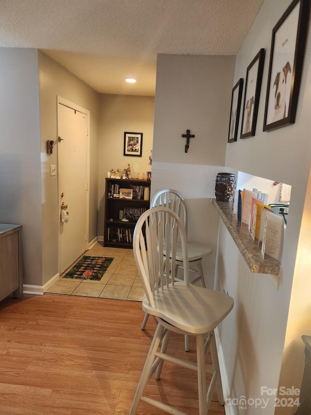 dining room featuring light wood-type flooring and a textured ceiling