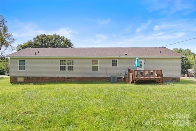 rear view of house featuring a lawn, cooling unit, and a wooden deck