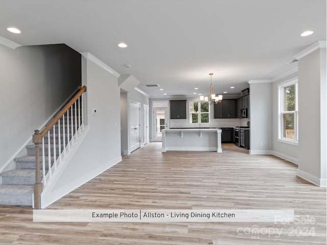 unfurnished living room with ornamental molding, light hardwood / wood-style floors, and a notable chandelier