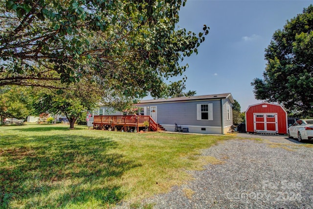 view of front of property featuring a front yard, a deck, and a storage unit