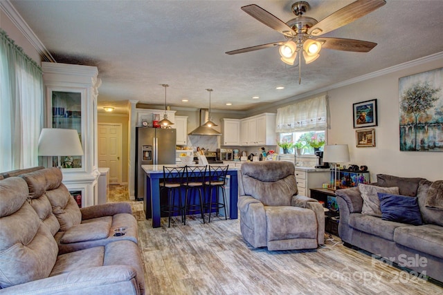 living room with light wood-type flooring, crown molding, ceiling fan, and a textured ceiling