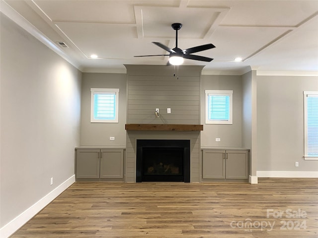 unfurnished living room with ceiling fan, a large fireplace, light hardwood / wood-style floors, and ornamental molding