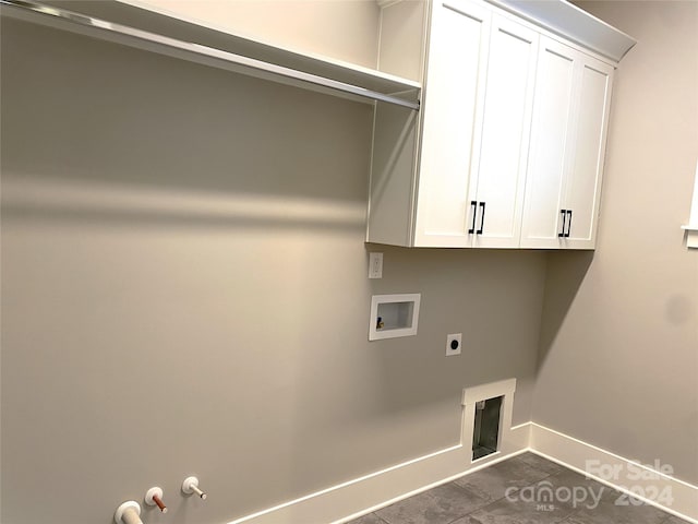 clothes washing area featuring electric dryer hookup, gas dryer hookup, cabinets, washer hookup, and dark tile patterned floors