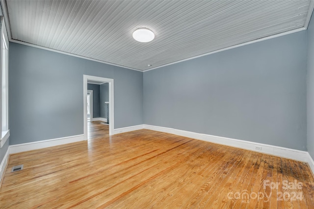 empty room with crown molding and hardwood / wood-style flooring