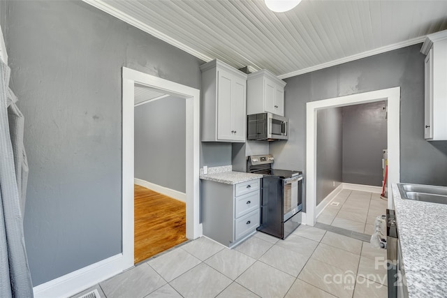 kitchen with ornamental molding, appliances with stainless steel finishes, and light wood-type flooring