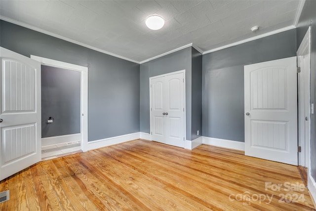 unfurnished bedroom featuring hardwood / wood-style flooring and ornamental molding