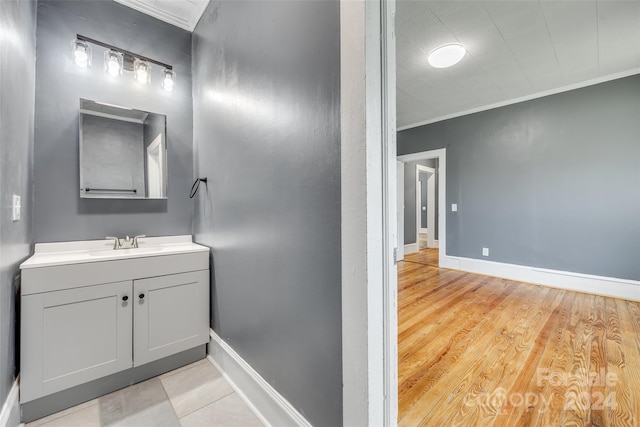 bathroom with ornamental molding, vanity, and wood-type flooring