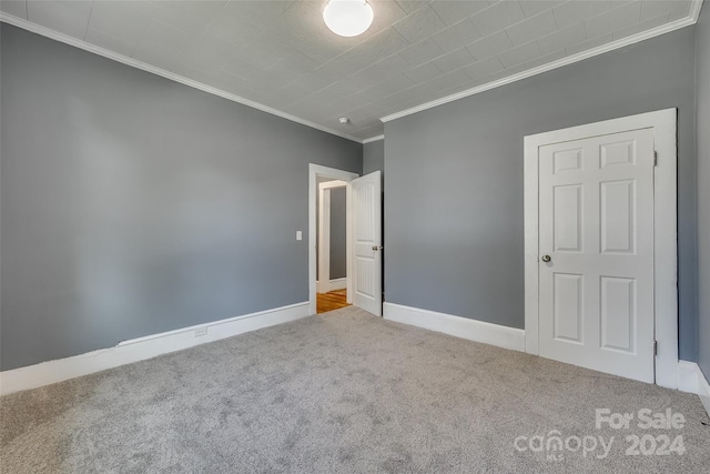 unfurnished bedroom with ornamental molding and carpet