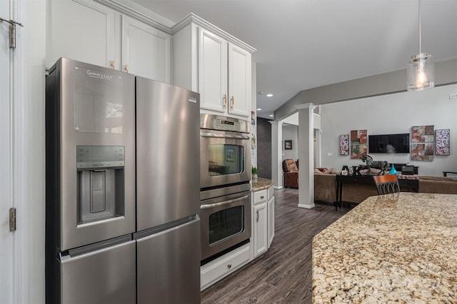 kitchen with light stone countertops, stainless steel appliances, decorative light fixtures, dark hardwood / wood-style floors, and white cabinetry