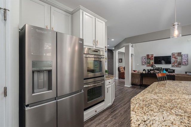 kitchen featuring open floor plan, white cabinets, stainless steel appliances, ornate columns, and dark wood-style flooring