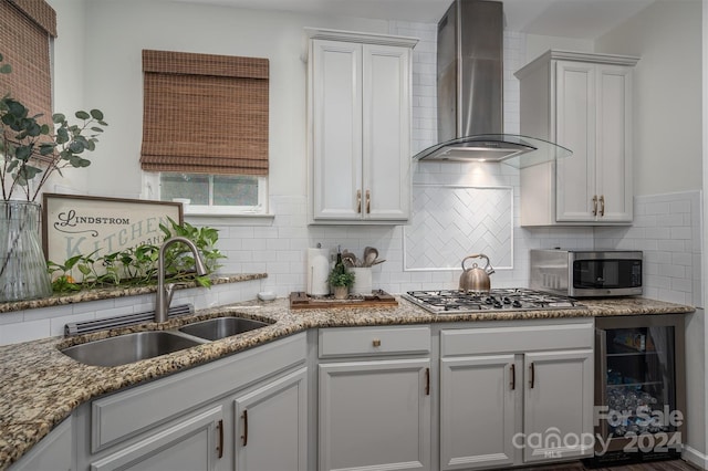 kitchen with white cabinetry, sink, wall chimney exhaust hood, stainless steel appliances, and beverage cooler