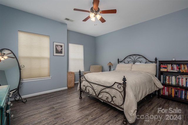 bedroom featuring visible vents, a ceiling fan, baseboards, and wood finished floors