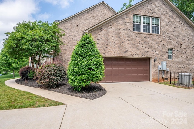 view of home's exterior featuring brick siding, driveway, and an attached garage