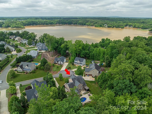 drone / aerial view with a residential view, a forest view, and a water view