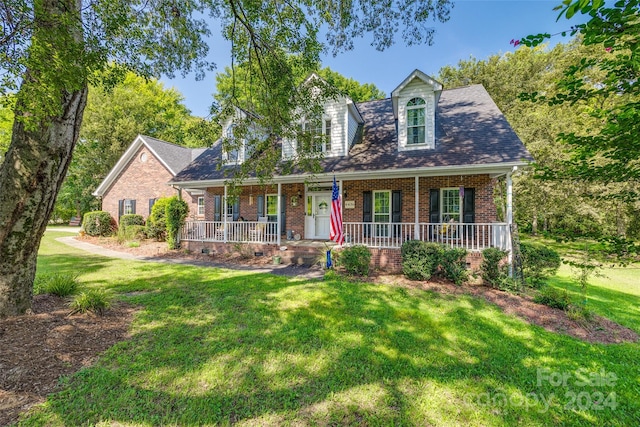 cape cod home featuring a front yard and a porch