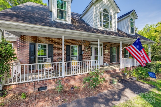 cape cod-style house featuring covered porch