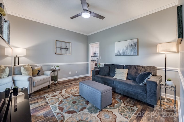 living room with ornamental molding, dark wood-type flooring, and ceiling fan