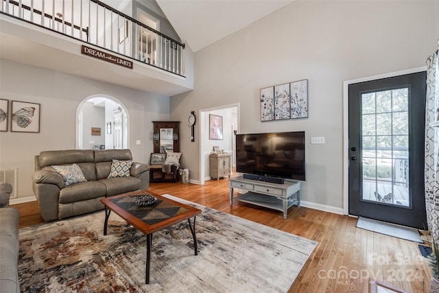 living room with high vaulted ceiling and hardwood / wood-style flooring