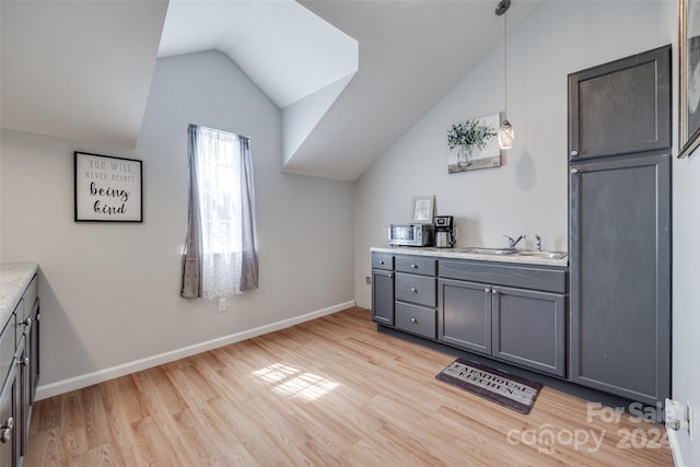 interior space with wood-type flooring, vaulted ceiling, and vanity