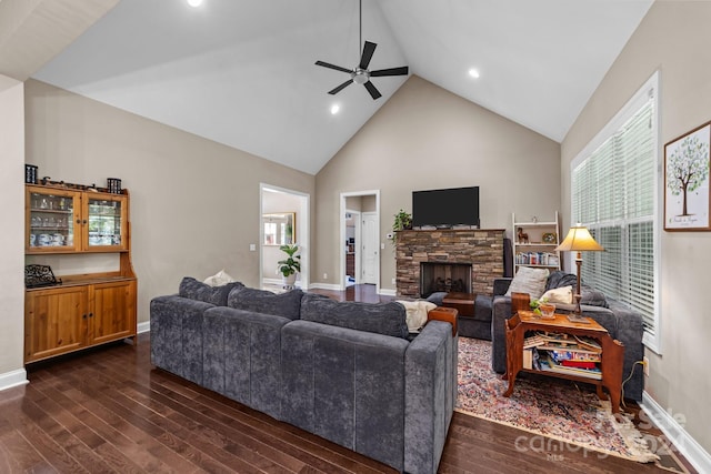 living room featuring a fireplace, dark wood-type flooring, high vaulted ceiling, a healthy amount of sunlight, and ceiling fan