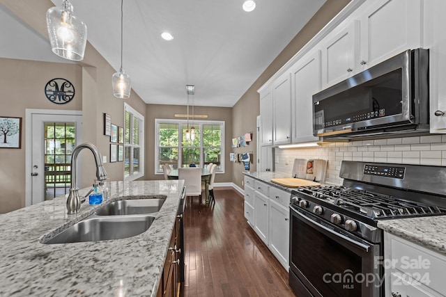 kitchen with a healthy amount of sunlight, white cabinets, range with gas stovetop, and sink