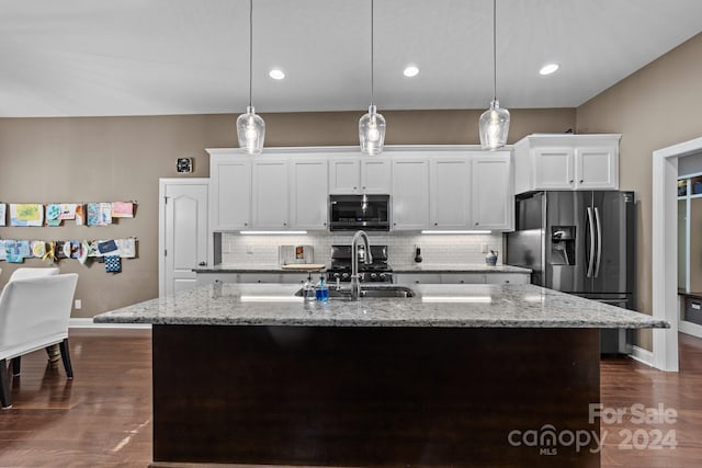 kitchen with dark wood-type flooring, stainless steel appliances, white cabinetry, and a kitchen island with sink