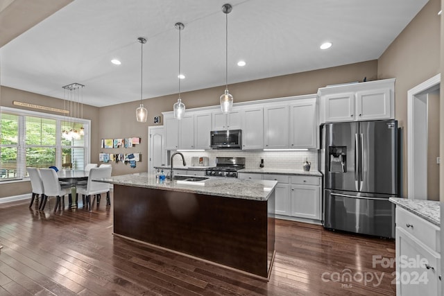 kitchen featuring hanging light fixtures, dark hardwood / wood-style flooring, appliances with stainless steel finishes, and white cabinets