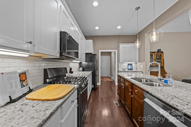 kitchen with light stone counters, dark hardwood / wood-style flooring, white cabinetry, sink, and black appliances