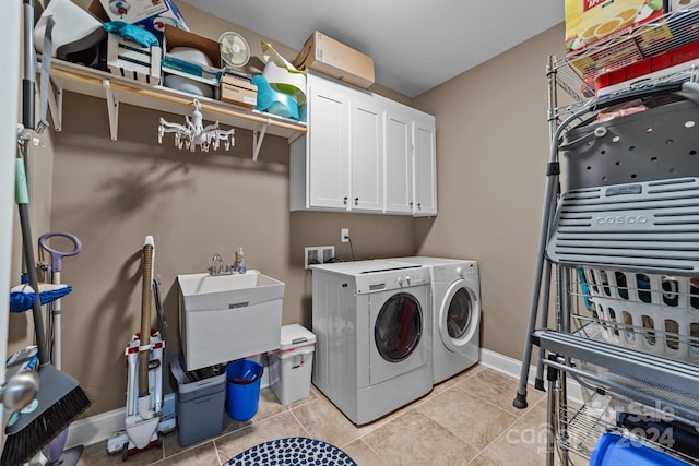 washroom featuring cabinets, sink, washer and clothes dryer, and light tile patterned flooring