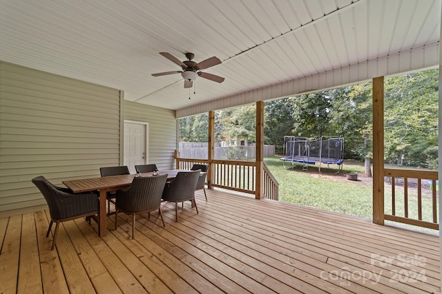 deck with a yard, ceiling fan, and a trampoline