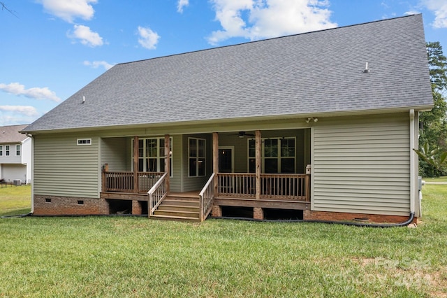 rear view of house featuring ceiling fan and a lawn