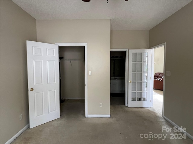 unfurnished bedroom featuring a closet, concrete flooring, and a textured ceiling