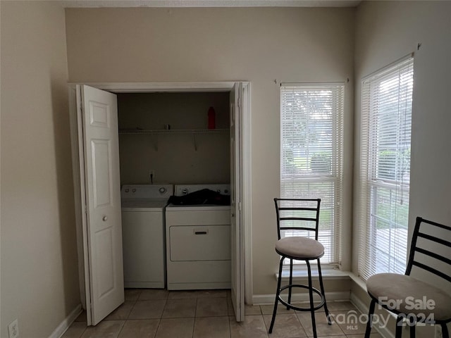 laundry area with separate washer and dryer and light tile patterned floors