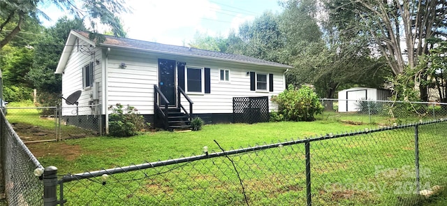 back of house featuring a yard and a shed