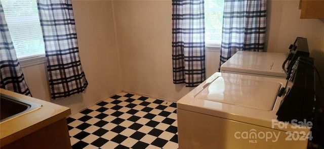 clothes washing area with washer and dryer and sink