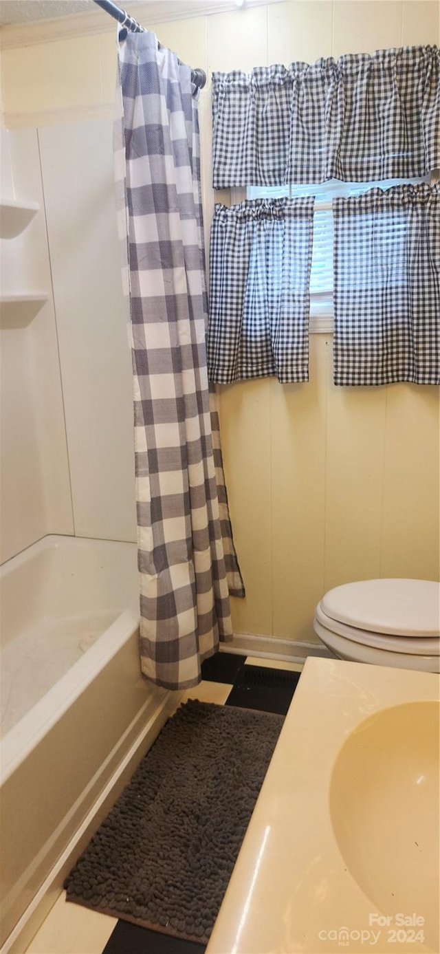 bathroom featuring shower / bath combination with curtain and toilet