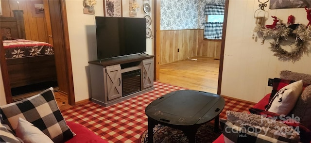 living room featuring wooden walls and hardwood / wood-style flooring