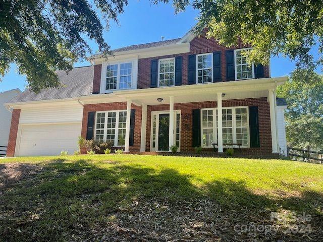 colonial home with a garage and a front lawn