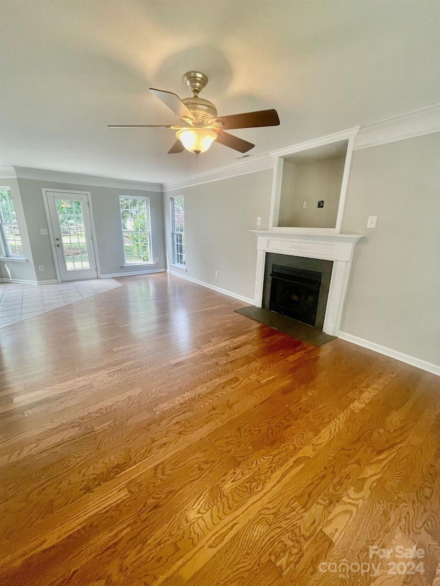 unfurnished living room with light wood-type flooring, ceiling fan, and crown molding