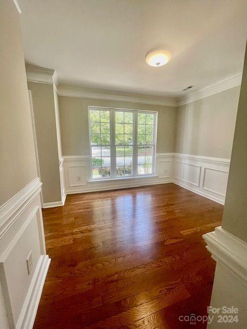 unfurnished room with crown molding and dark hardwood / wood-style floors