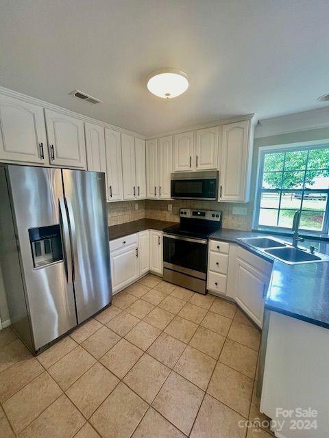 kitchen with white cabinets, tasteful backsplash, stainless steel appliances, and sink