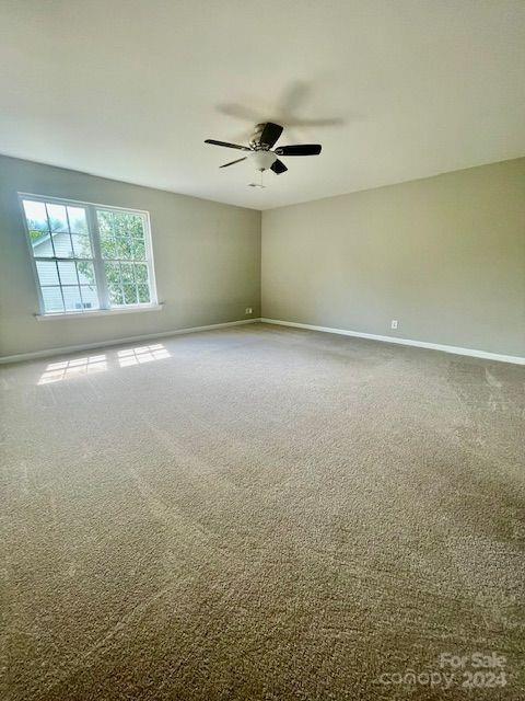 spare room featuring carpet flooring and ceiling fan