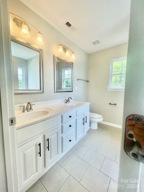 bathroom with vanity, toilet, and tile patterned floors