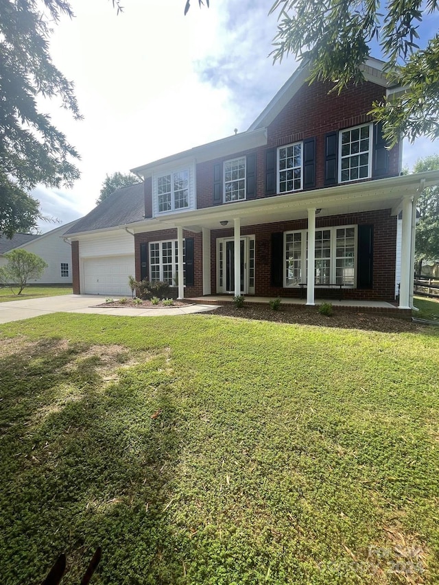 view of front facade featuring a garage, a front lawn, and a porch