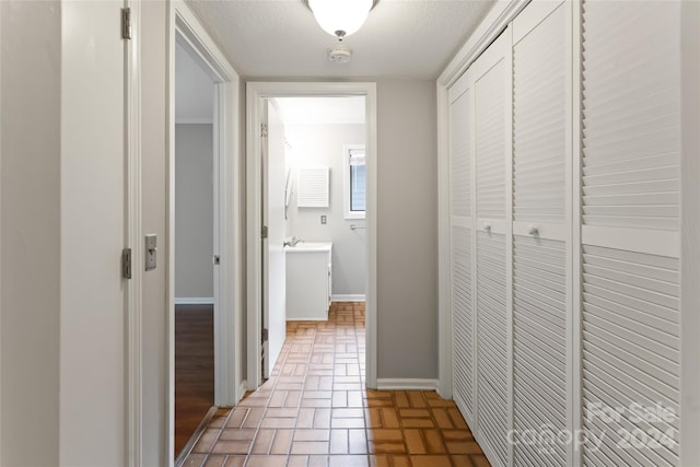 corridor featuring a textured ceiling