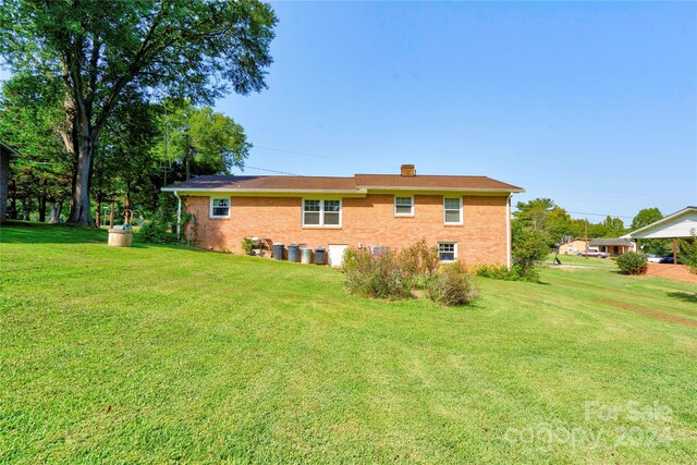 rear view of house featuring a lawn