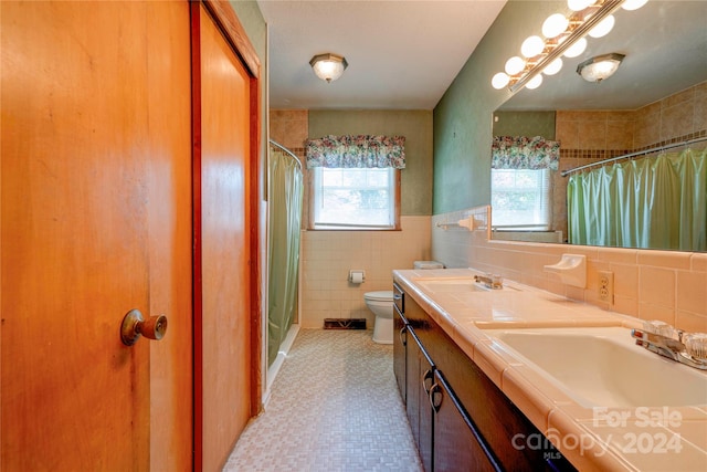 bathroom featuring vanity, tile walls, toilet, a shower with curtain, and decorative backsplash